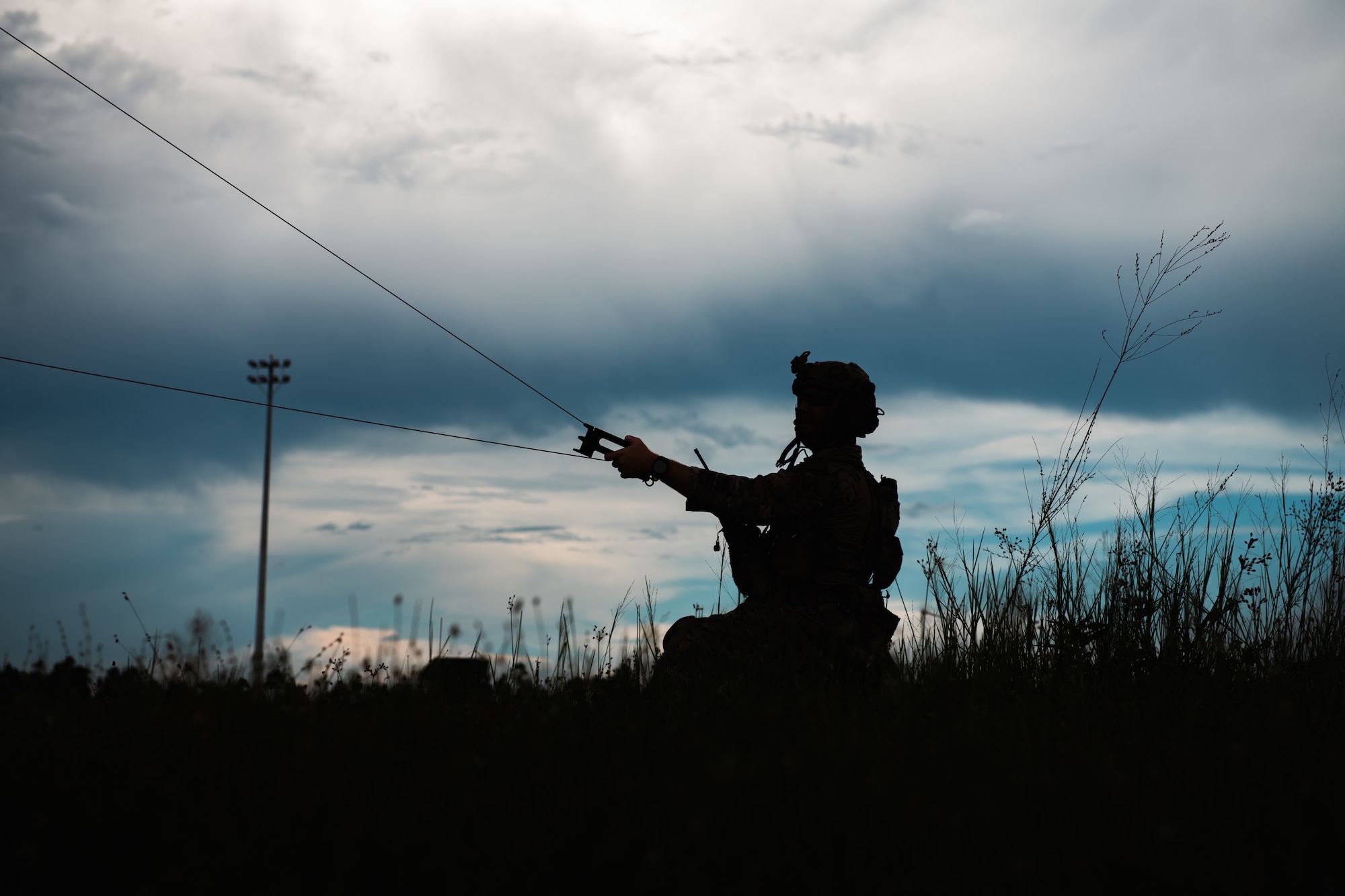 An Airmen anchors a radio antenna.