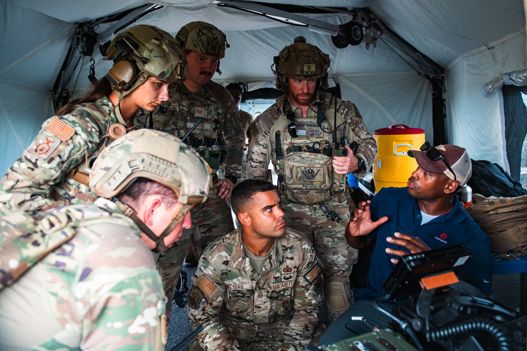 Airmen listen to instructions on operating a communications system.
