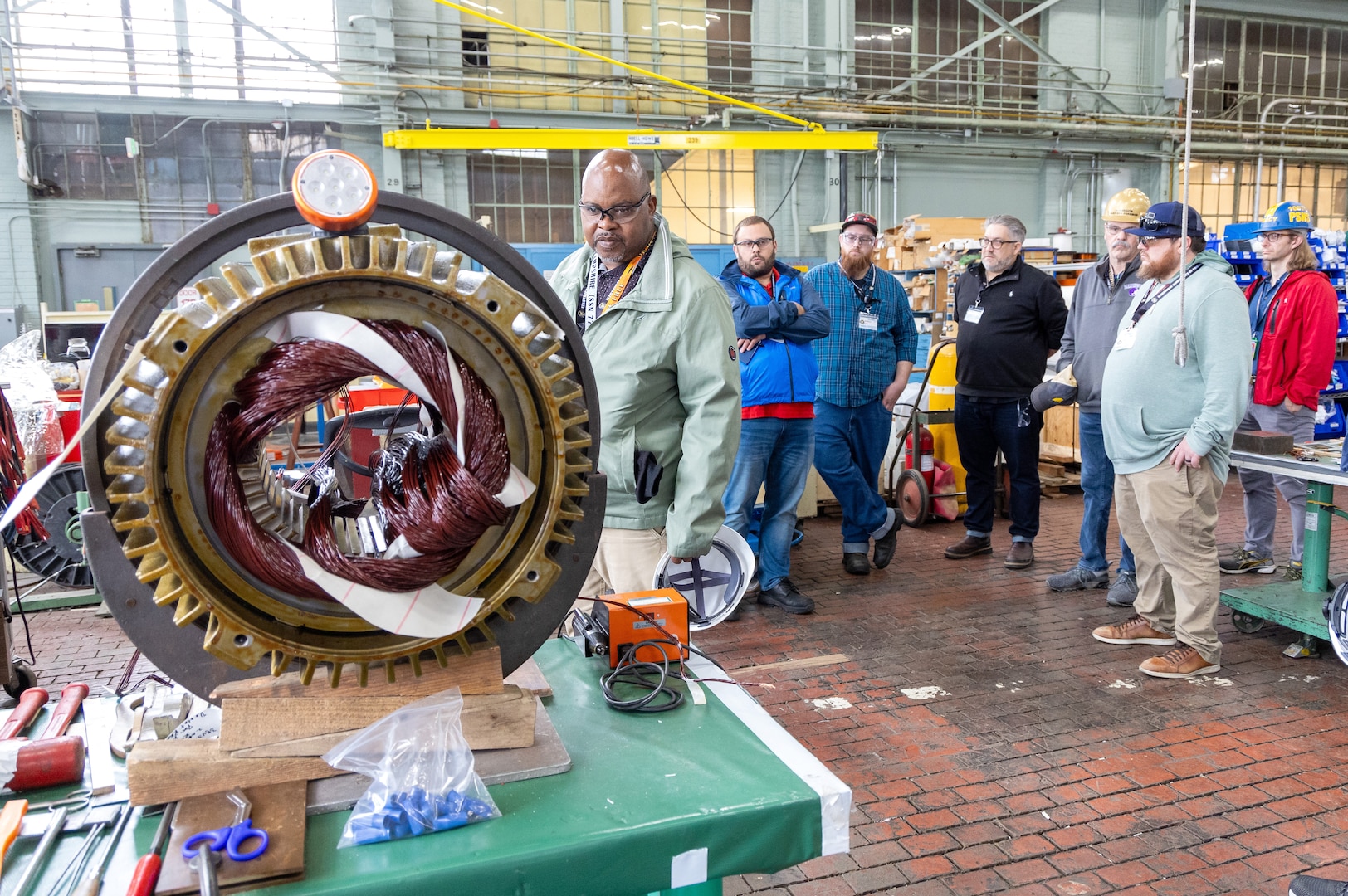 Kevin Callines, an Electrical Community of Practice representative from Norfolk Naval Shipyard, examines a motor
in the process of being rewound, May 21, 2024, while touring Building 427 at Puget Sound Naval Shipyard & Intermediate Maintenance Facility in Bremerton, Washington, as part of
the group's three-day conference at the Kitsap Conference Center in downtown Bremerton, Washington. (U.S. Navy photos by Wendy Hallmark)