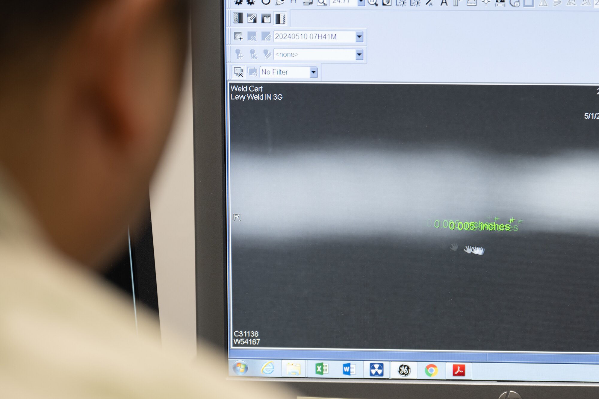 Airman views an x-ray of an aircraft part.