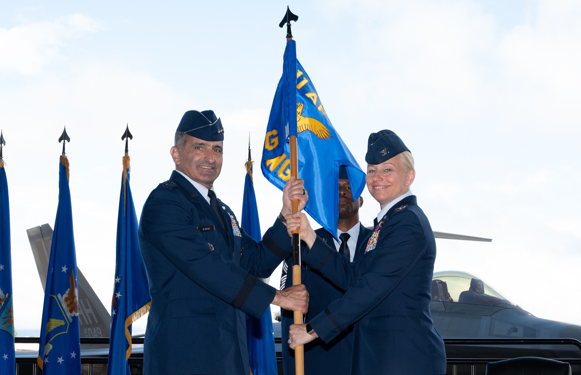 Airmen hold a guidon.