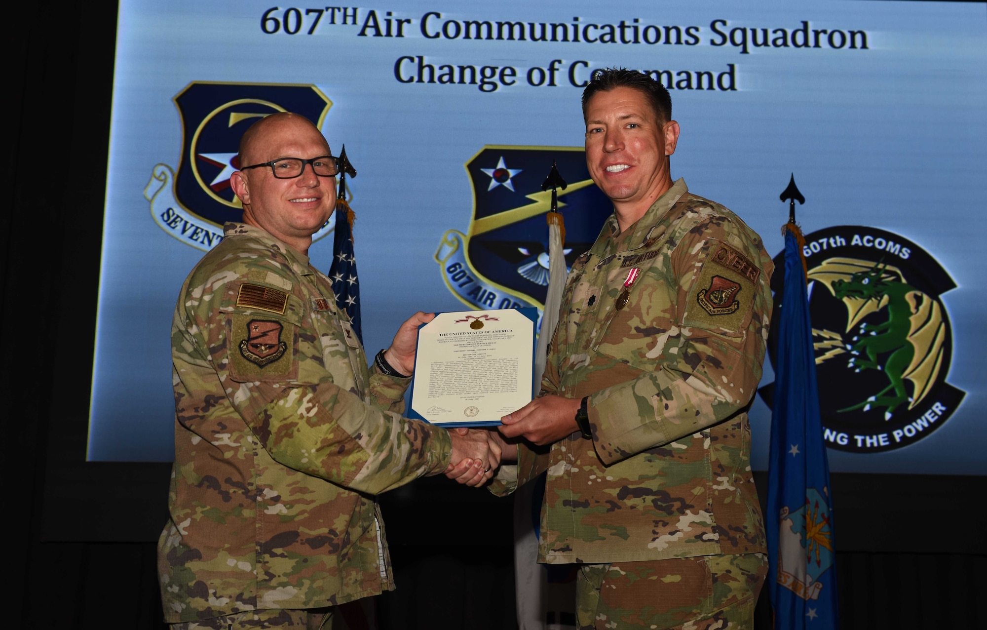 U.S. Air Force Lt. Col. Jonathan Dietz, right, accepts the Meritorious Service Medal from Col. Daniel Biehl, 7th Air Operations Center deputy commander, during a change of command ceremony at Osan Air Base, Republic of Korea, July 19, 2024. After relinquishing command, Dietz will continue to serve within the 7th AF and its missions. (U.S. Air Force photo by Staff Sgt. Kahdija Slaughter)