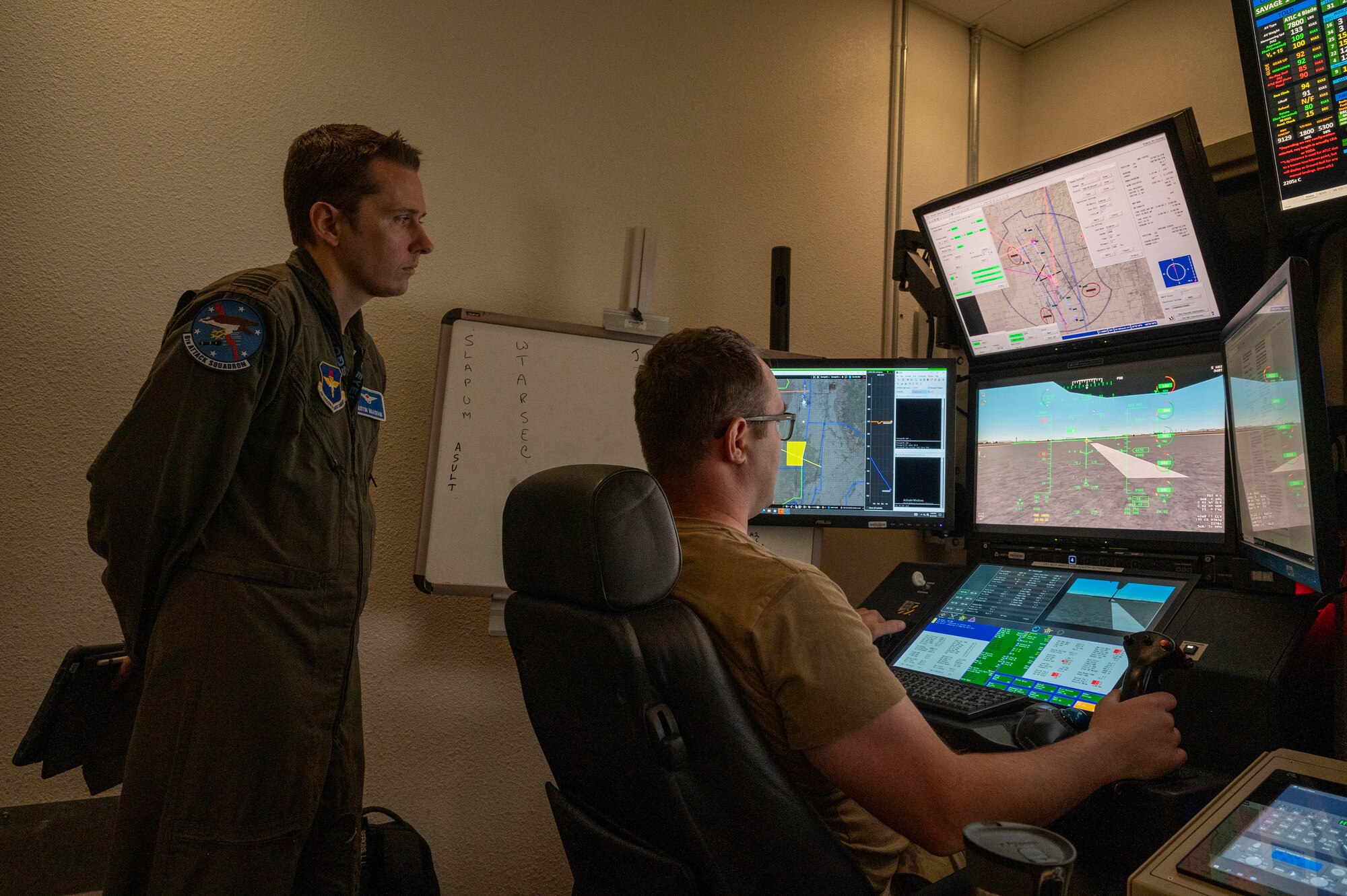 Royal Netherlands Air Force Maj. Justin Maasdam, 6th Attack Squadron instructor pilot, left, monitors a student pilot in a ground control station training simulator at Holloman Air Force Base, New Mexico, June 26, 2024. The 49th Wing’s purpose in this collaboration is to assist in training MQ-9 Reaper pilots and sensor operators from the U.S. and allied nations, fostering international cooperation and ensuring consistent training standards for future NATO operations. (U.S. Air Force photo by Senior Airman Isaiah Pedrazzini