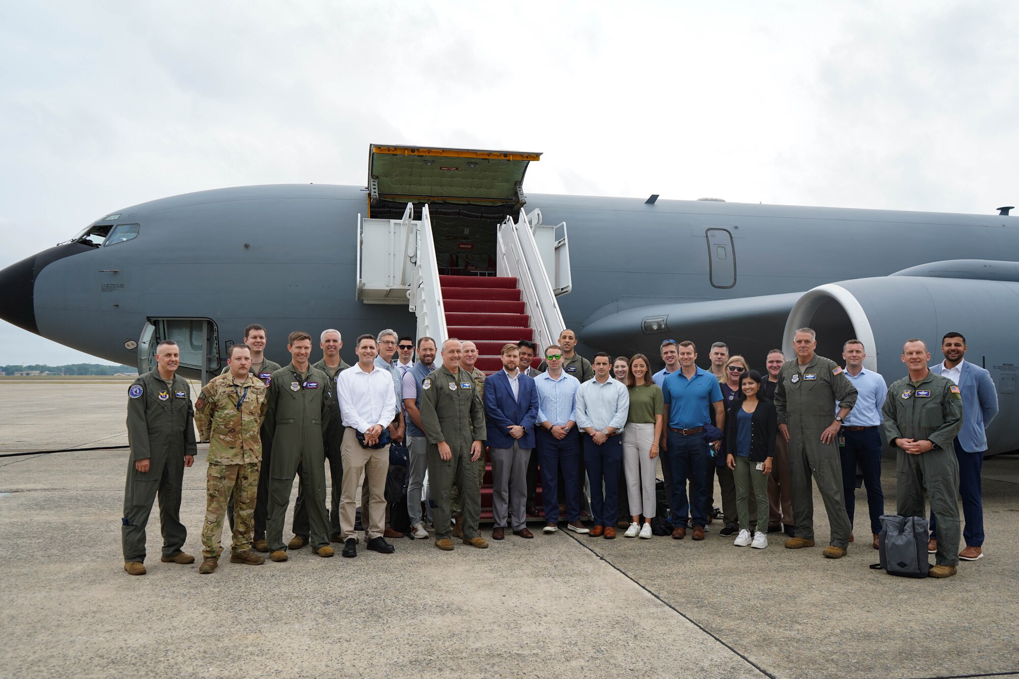 Gen Mike Minihan, Air Mobility Command commander, and Chief Master Sgt Jamie Newman, AMC command chief, take a group photo with a Congressional delegation before boarding a KC-135 Stratotanker to demonstrate the importance of connectivity across the mobility fleet, July 22, 2024.