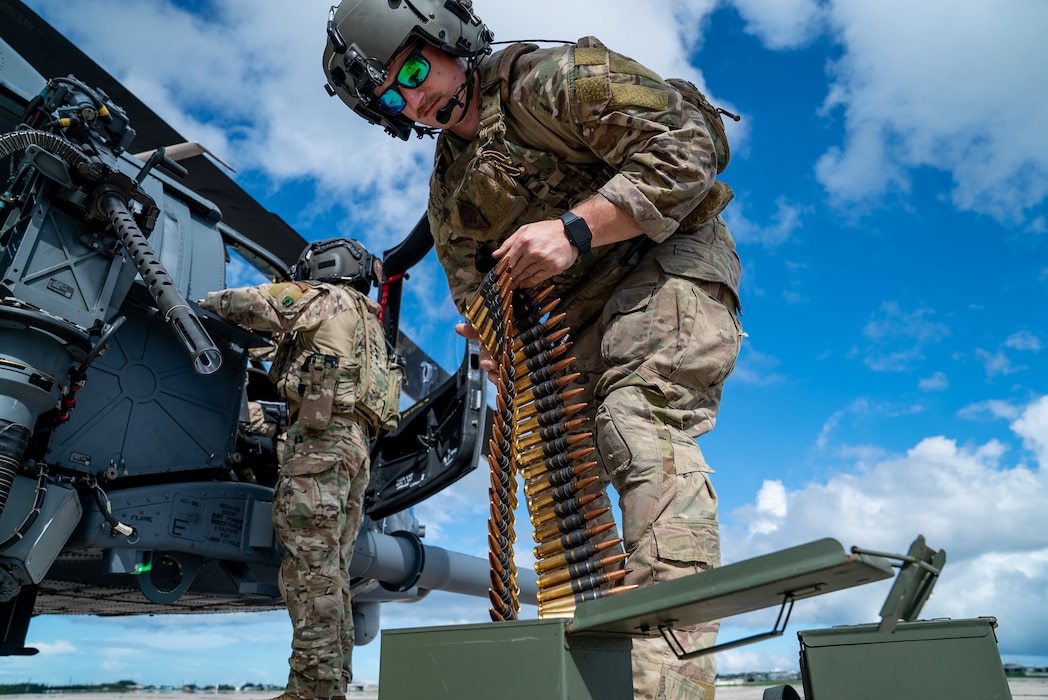 U.S. Air Force Staff Sgt. Dakota Dennis, 33rd Rescue Squadron special missions aviator, loads ammo into a GAU-21 weapon system on an HH-60W Jolly Green II at Kadena Air Base, Japan, July 17, 2024. The 33rd RQS provides a ready combat search and rescue platform to aid in exercises and real-world operations in the Indo-Pacific Command area of responsibility. (U.S. Air Force photo by Senior Airman Cedrique Oldaker)