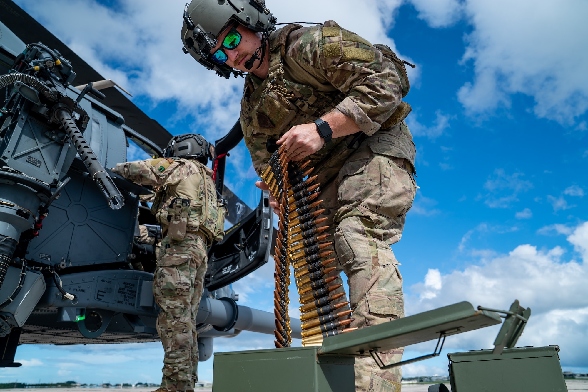 U.S. Air Force Staff Sgt. Dakota Dennis, 33rd Rescue Squadron special missions aviator, loads ammo into a GAU-21 weapon system on an HH-60W Jolly Green II at Kadena Air Base, Japan, July 17, 2024. The 33rd RQS provides a ready combat search and rescue platform to aid in exercises and real-world operations in the Indo-Pacific Command area of responsibility. (U.S. Air Force photo by Senior Airman Cedrique Oldaker)