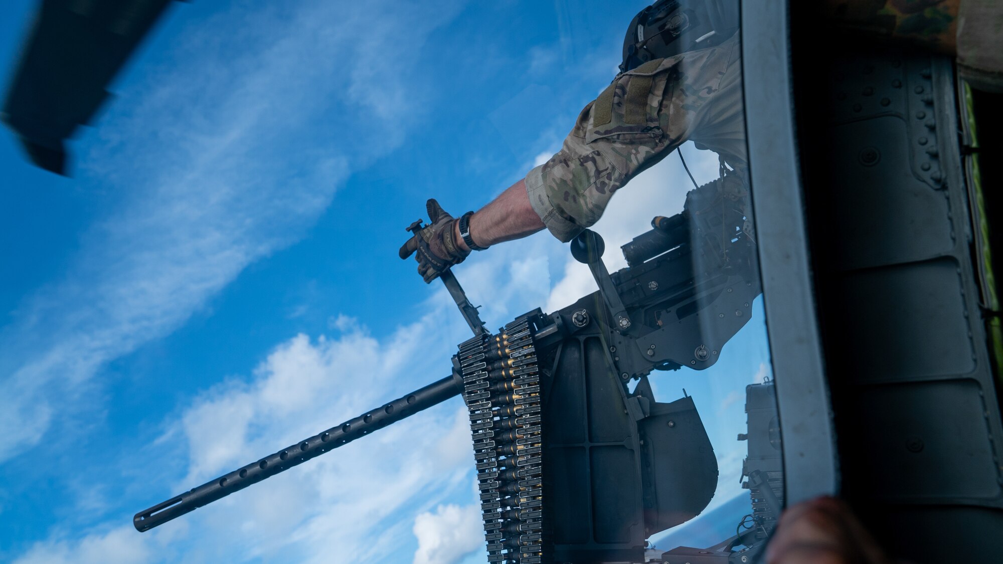 A U.S. Air Force special missions aviator with the 33rd Rescue Squadron operates a GAU-21 weapon system on an HH-60W Jolly Green II during routine training over the Pacific Ocean, July 17, 2024. The 33rd RQS maintains readiness for mobilization, deployment and employment of helicopters, and rescue of U.S. and allied military members and civilian personnel. (U.S. Air Force photo by Senior Airman Cedrique Oldaker)