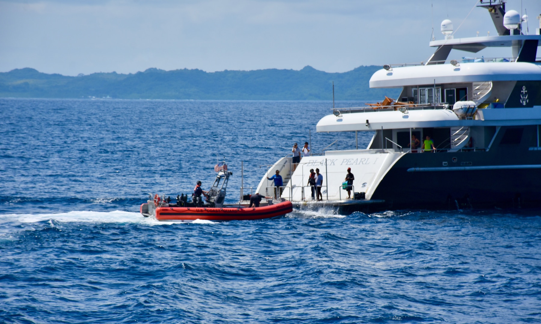 The crew of the USCGC Oliver Henry (WPC 1140) pick up the crewmember who monitored the tow overnight aboard the Black Pearl 1 as they complete the rescue operation of the motor yacht Black Pearl 1 and the 11 crew aboard, ensuring its safe arrival and mooring in the Republic of Palau on July 22, 2024, at 11:22 a.m. ChST, the Oliver Henry crew transferred the Black Pearl's tow to the 75-foot Palau-flagged tug SSC Techall, just offshore Palau. (U.S. Coast Guard photo)