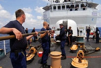 Crew members of the U.S. Coast Guard Cutter Thetis clean the 76mm Oto Melara gun after firing 54 rounds at the ex-USS Connolly during the sinking exercise portion of UNITAS Gold.