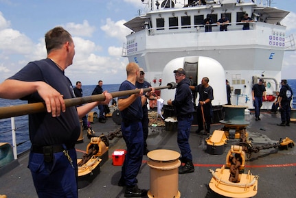 Crew members of the U.S. Coast Guard Cutter Thetis clean the 76mm Oto Melara gun after firing 54 rounds at the ex-USS Connolly during the sinking exercise portion of UNITAS Gold.