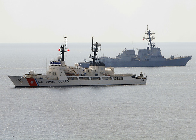 The Arleigh Burke-class guided-missile destroyer USS Chung-Hoon and U.S. Coast Guard cutter Mellon pass each other during a surface gunfire exercise.