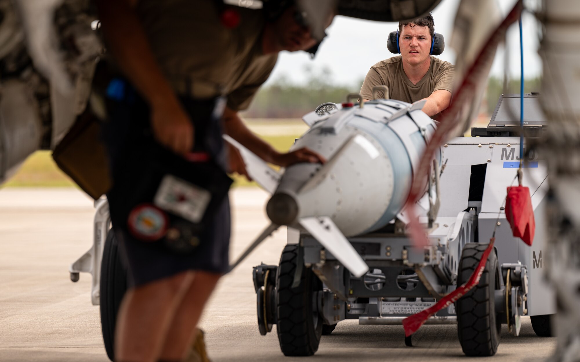 An airman loads a bomb onto an aircraft