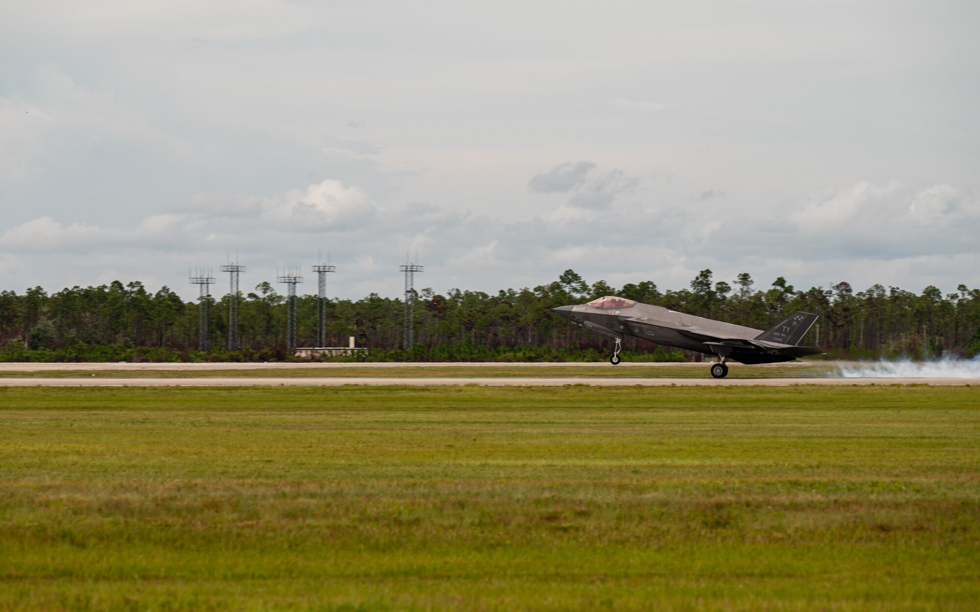 An aircraft lands on the flight line