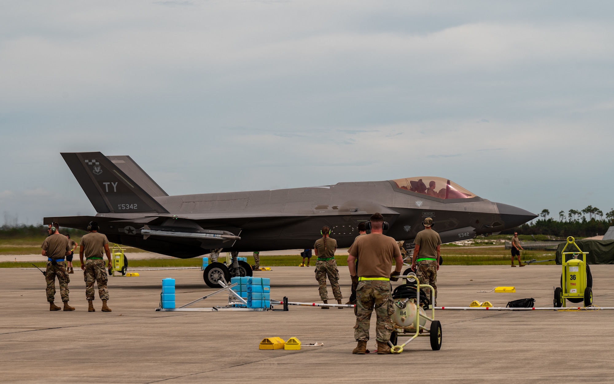 Airmen watch an aircraft taxi on the flightline