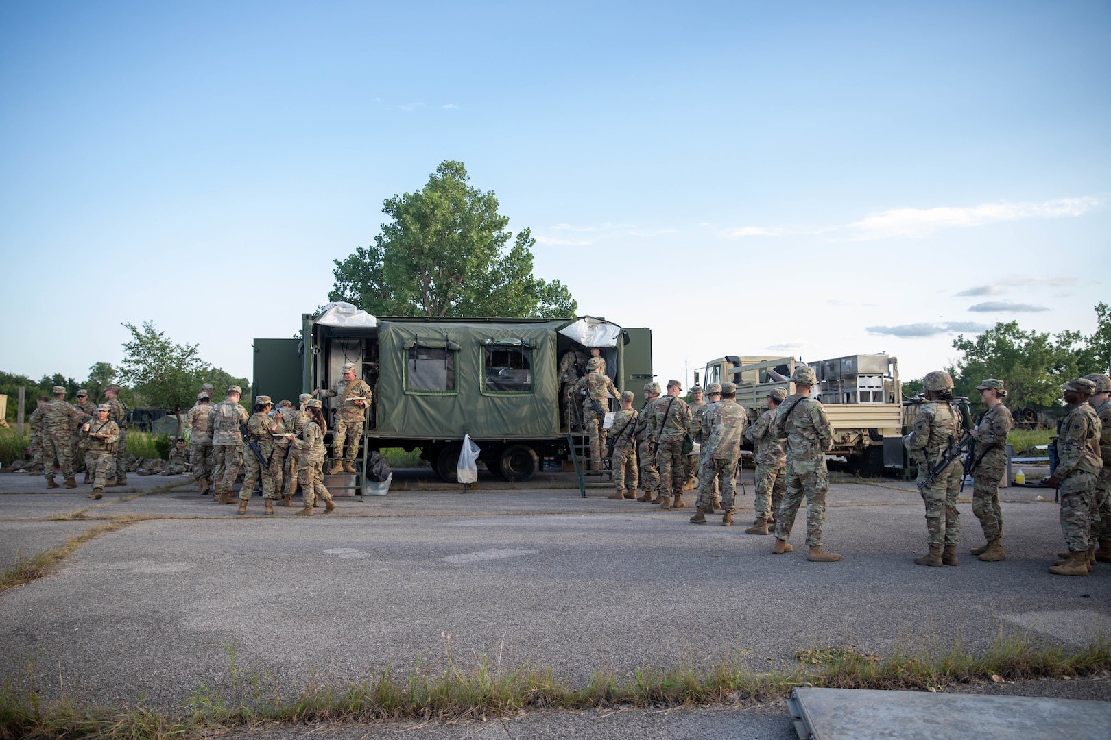 Oklahoma Army National Guard Soldiers from 700th Brigade Support Battalion, 45th Infantry Brigade Combat Team, get food from the mobile kitchen trailer at the brigade support area at Glenwood Training Area in Midwest City, Oklahoma, July 13, 2024. The 700th BSB manages and supplies all the 45th Infantry Brigade Combat Team’s maneuver battalions and their forward support companies with all of their commodities, including food, water, fuel, ammunition, parts, and maintenance. (Oklahoma National Guard photo by Sgt. Haden Tolbert)