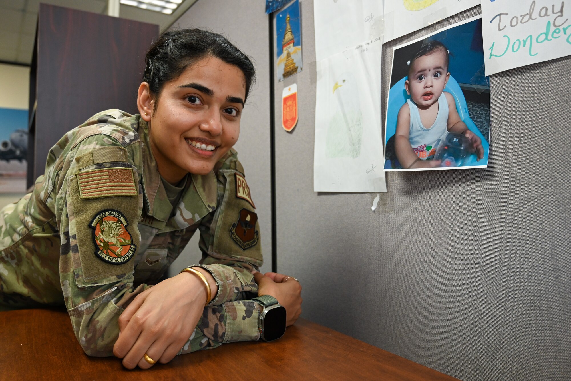 U.S. Air Force Airman 1st Class Benja Rayamajhi, 97th Force Support Squadron career development technician, poses in front of a picture of her daughter at Altus Air Force Base, Oklahoma, July 16, 2024. Rayamajhi was born and raised in Biratnagar, Nepal, where she eventually left for the United States to provide a better life for her daughter. (U.S. Air Force photo by Airman Lauren Torres)