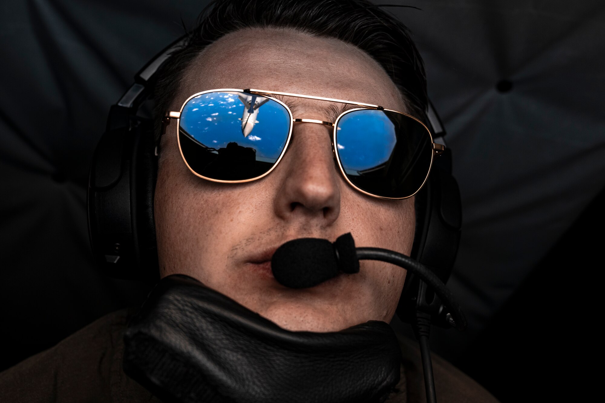 a b-1 is seen in the reflection of an airman's sunglasses
