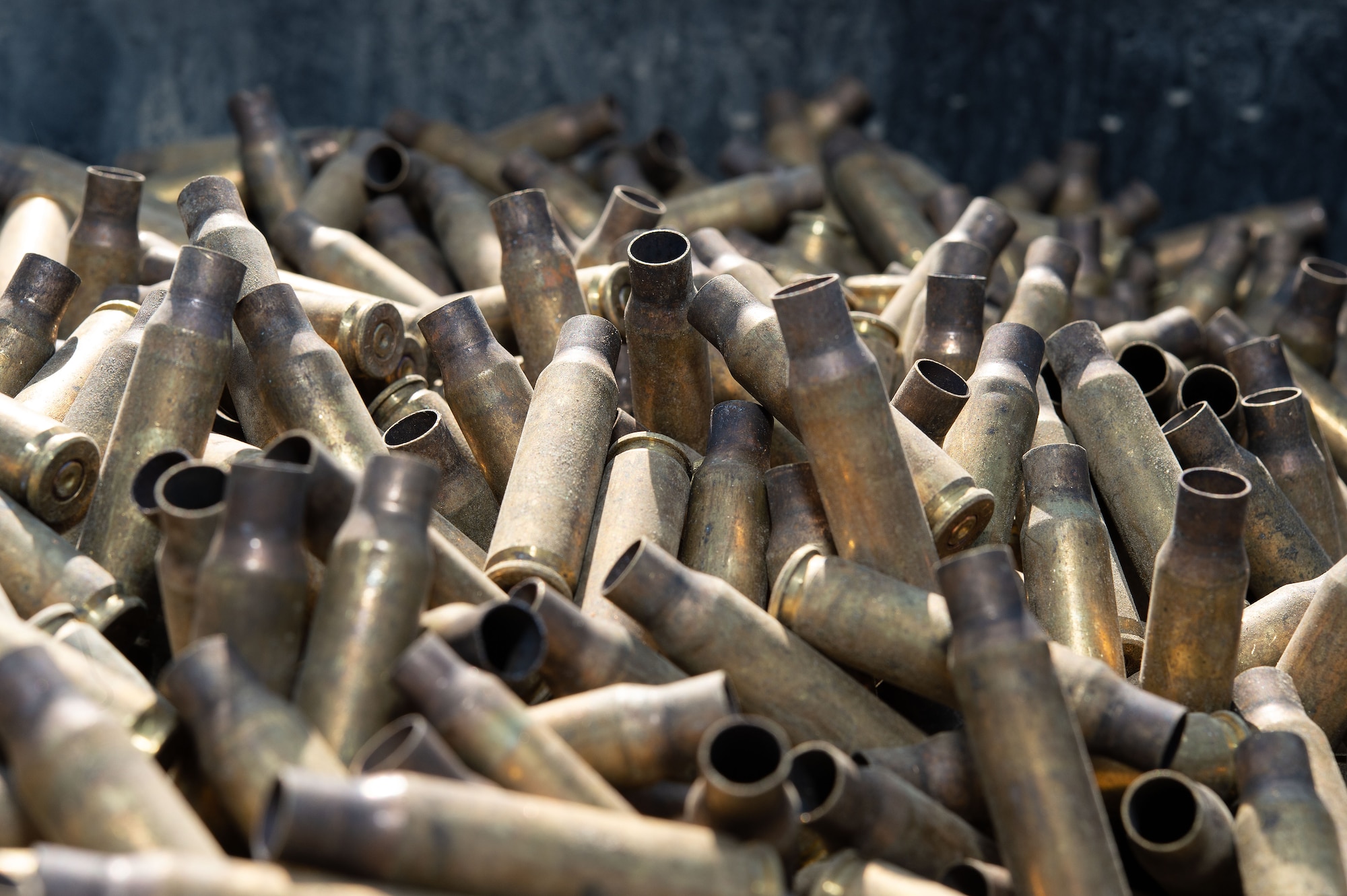 Spent small caliber brass munition cartridges sit in a 55-gallon waiting to be demilitarized using a deformer at Dover Air Force Base, Delaware, May 1, 2024. From its first use in February 2019, proceeds from brass sales have paid for the deformer and are now generating revenue for the base. (U.S. Air Force photo by Roland Balik)