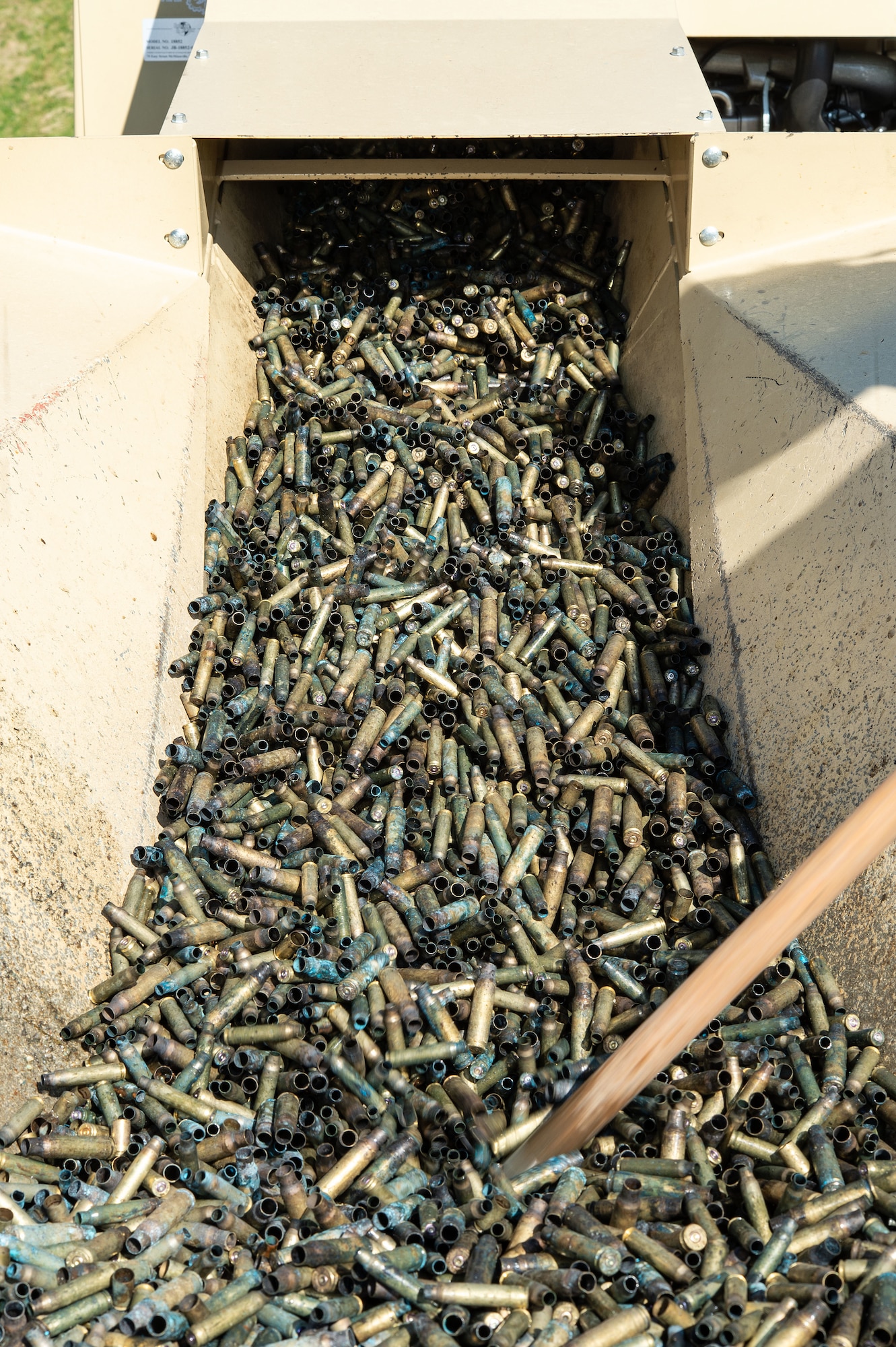 Spent small caliber brass munition cartridges move up the conveyor to be demilitarized by a deformer at Dover Air Force Base, Delaware, May 1, 2024. From its first use in February 2019, proceeds from brass sales have paid for the deformer and are now generating revenue for the base. (U.S. Air Force photo by Roland Balik)