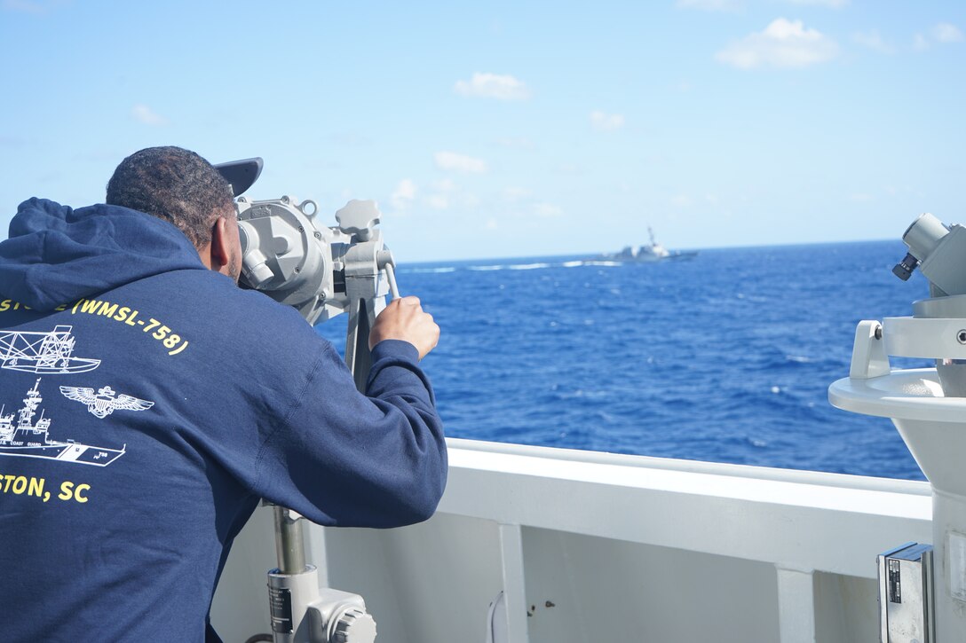 A Coast Guard Academy cadet aboard U.S. Coast Guard Cutter Stone (WMSL 758) observes Arleigh Burke-class destroyer USS Truxtun (DDG 103) while conducting maritime stability and security operations, June 3, 2024, in the Atlantic Ocean. (U.S Coast Guard photo by Ensign Alana Kickhoefer)