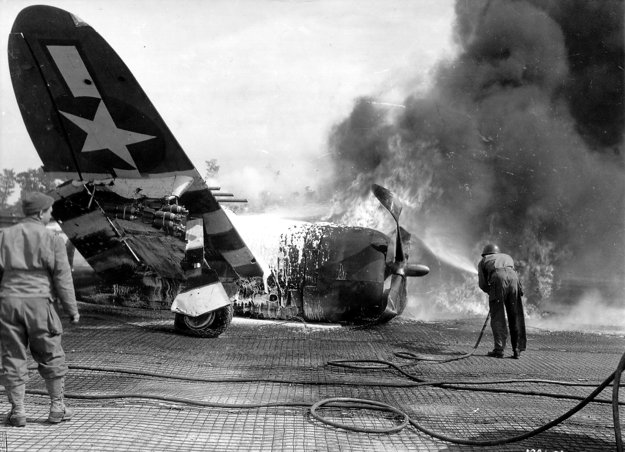 On June 21, 1944 a P-47D of the 406th Fighter Group’s 514th Fighter Squadron (squadron code O7-U) suffered a mishap at ALG A-6 and the aircraft was destroyed by fire. This may have been the incident in which 406th Fighter Squadron NCO Sgt. Glen W. Bloodworth braved the dangerous conditions to help put out the fire for which he was later awarded the Soldier’s Medal. Note the cluster of fragmentation bombs precariously hanging from the pylon of the upraised wing of the P-47, likely a cluster of six M41 fragmentation bombs on an M1A1 bomb rack configuration. (US Army photo via Flickr)