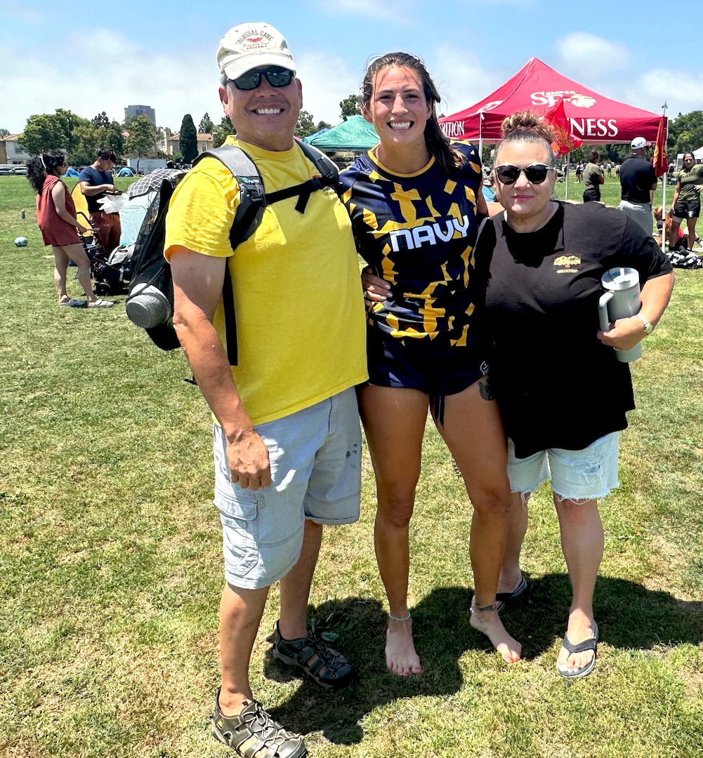 Navy Ensign Megan Neyen, Naval Base Pearl Harbor, Hawaii, stops for a photo with her dad, Marine veteran Terry Norris, and her step-mom, Sylvia, during the Armed Services Women's Rugby Championship at Nobel Field in San Diego, California (U.S. Army photo by Shannon Collins).