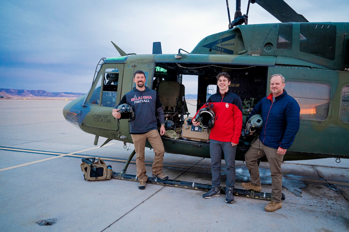 Men pose for a photo with aircraft.