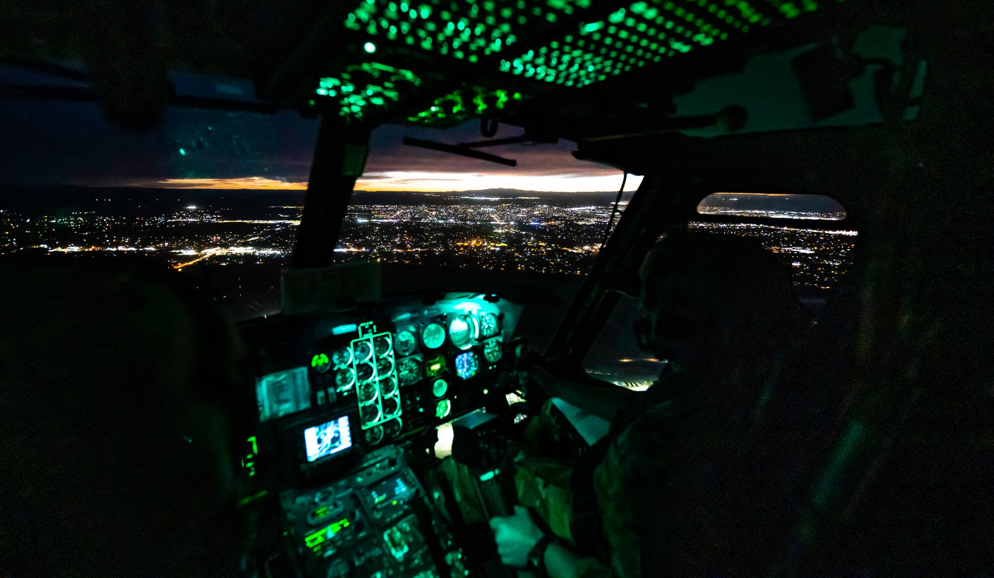An aircraft flying over a city at night.