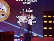 Assistant Secretary of the Air Force, Honorable Alex Wagner, left, congratulates U.S. Army veteran J.P. Lane for earning the Heart of the Team Award for Team Army at the send-off ceremony during the 2024 Department of Defense Warrior Games