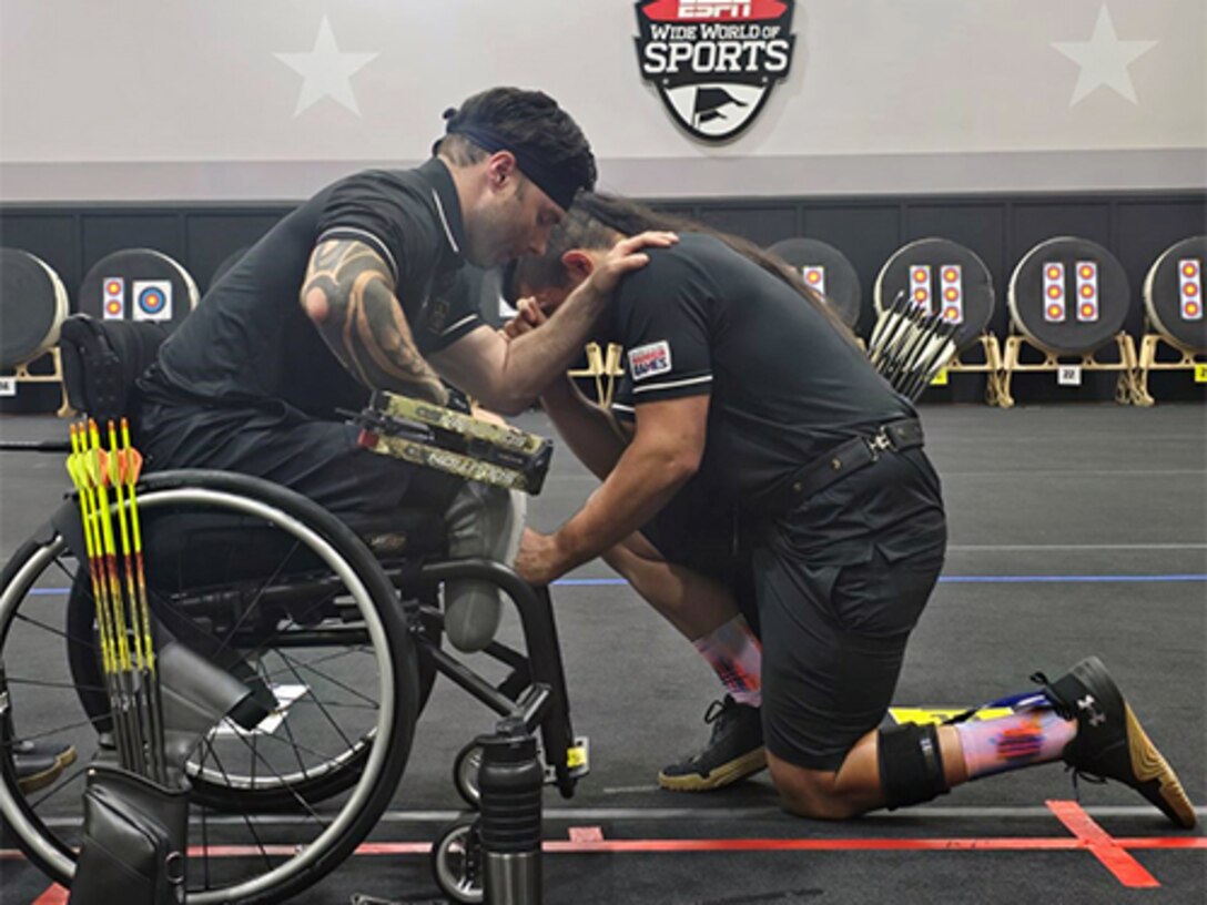JP Lane offered support and prayer to teammate and Ultimate Champion athlete Justin Mathers before Mathers competed and won gold in an archery competition at the 2024 DOD Warrior Games