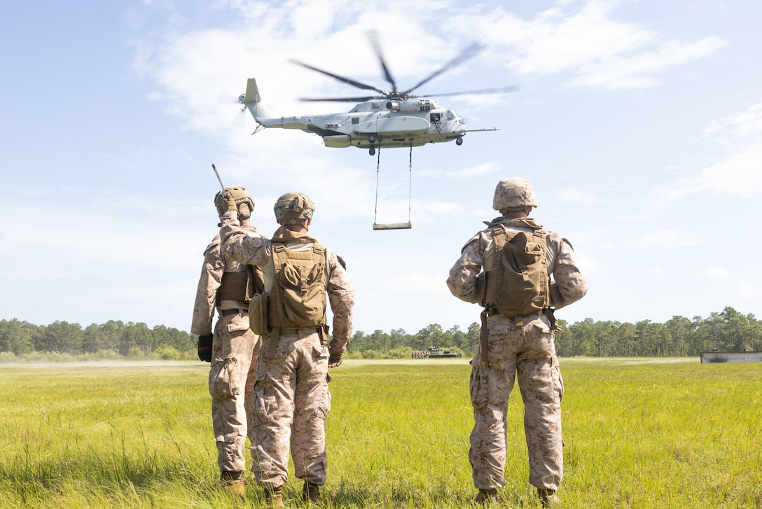 U.S. Marines with 2nd Distribution Support Battalion, Combat Logistics Regiment 2, 2nd Marine Logistics Group, observe as the attached heavy beam is moved during helicopter support team operations at Tactical Landing Zone Condor on Camp Lejeune, North Carolina, July 18, 2024. 2nd DSB conducted the training to prepare Marines to manage activities at landing zones; facilitate the pickup, movement, and landing of helicopter-borne troops, equipment, and supplies. (U.S. Marine Corps photo by Lance Cpl. Franco Lewis)