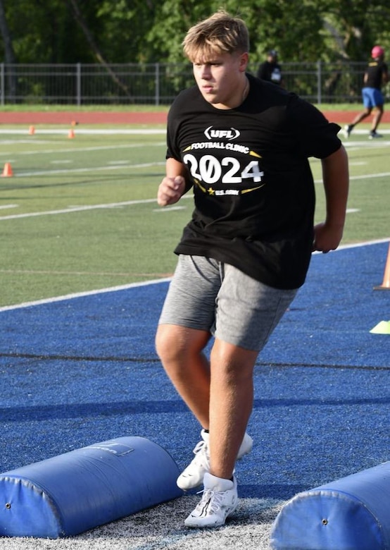 boy runs though football clinic drills.