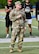 Man in Army uniform standing on football field speaking