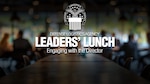 White text on a blurred background of employees sitting at a table