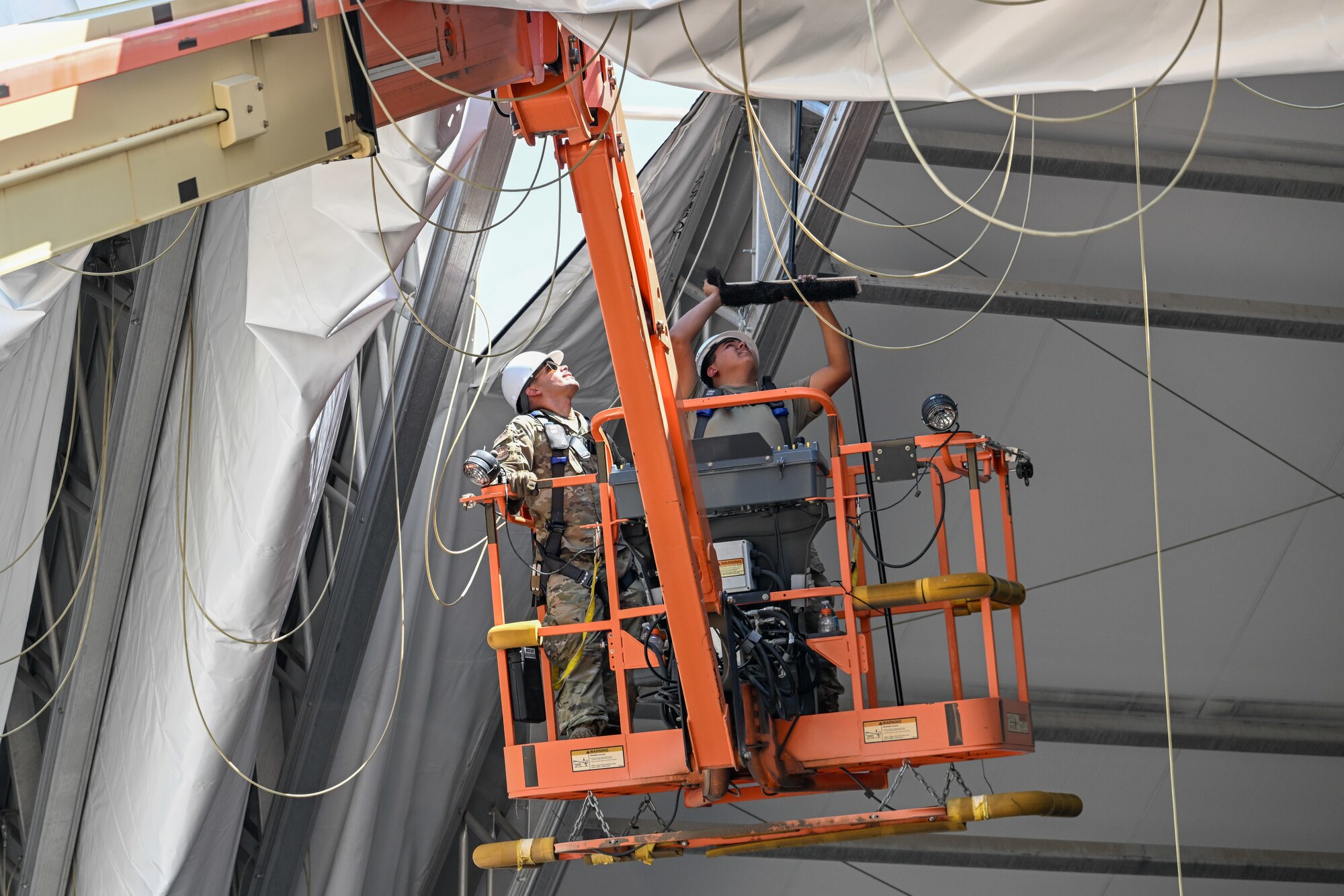 Airmen from the 635th Materiel Maintenance Squadron, based at Holloman Air Force Base, New Mexico, complete repairs on a clamshell tension fabric shelter system for 309th Aircraft Maintenance Group at Hill Air Force Base, Utah. The shelter stores critical aircraft parts and is used for “pack-and-crate” operations, where aircraft are prepared for ground or air transportation. (U.S. Air Force photo by Cynthia Griggs)