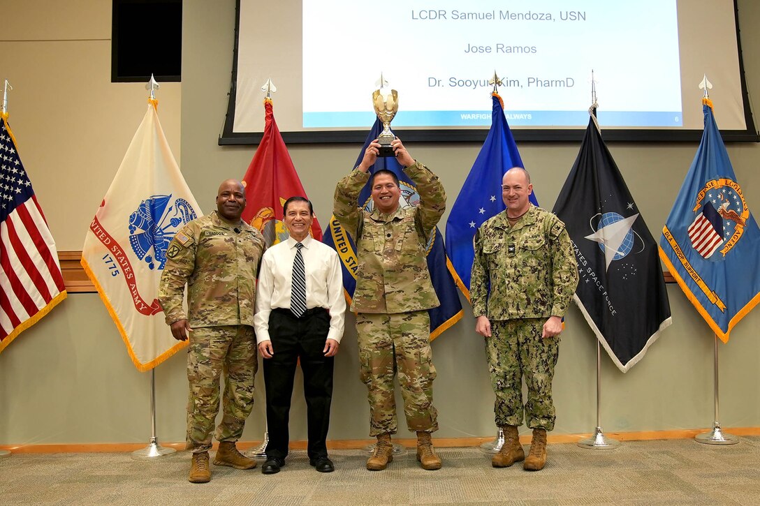 The Defense Logistics Agency Troop Support Commander Army Brig. Gen. Landis Maddox, left, poses with members of the Medical supply chain's Customer Pharmacy Operation's Team (left to right, Jose Ramos, Air Force Lt. Col. Francisco Boral and Navy Capt. Bill Kelly) during the organizations awards ceremony, July 17, in Philadelphia.
