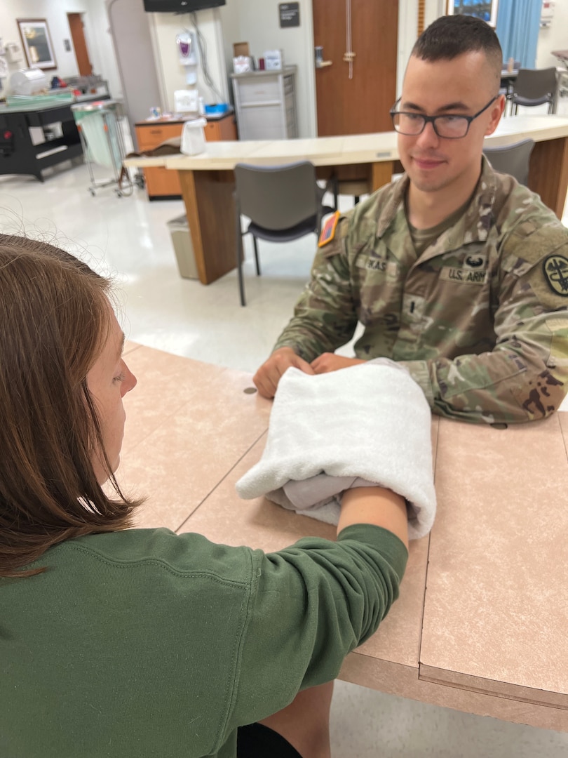 Doctor treating patient with large towel wrapped around her hand.