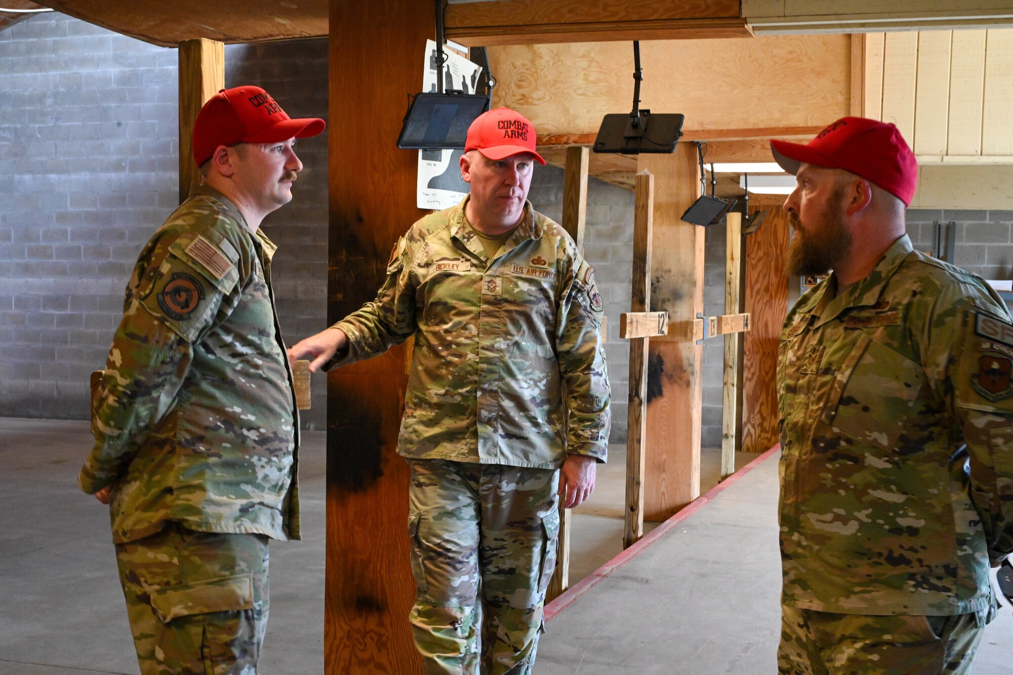 U.S. Air Force Tech. Sgt Casey Snyder, 97th Security Forces Squadron (SFS) combat arms training and maintenance noncommissioned officer in charge, and Staff Sgt. Dakota Reinsch, 97th SFS vehicle control noncommissioned officer in charge, speak to Chief Master Sgt. Chad Bickley, command chief of Air Education and Training Command, at Altus Air Force Base, Oklahoma, July 10, 2024. Bickley highlighted the importance of staying combat ready. (U.S. Air Force photo by Senior Airman Miyah Gray)