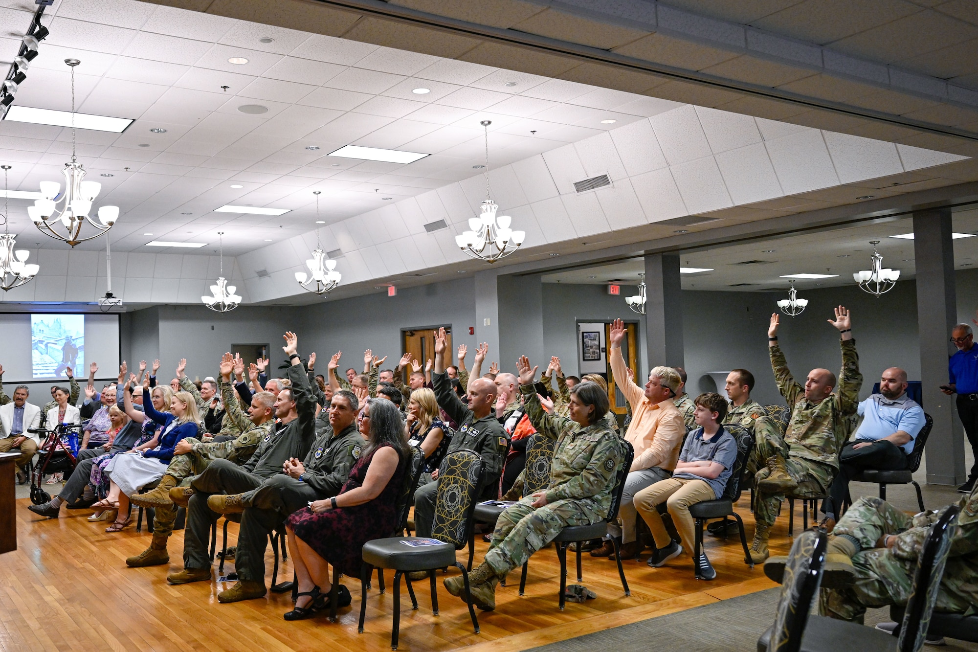 A crowd raises their hands.