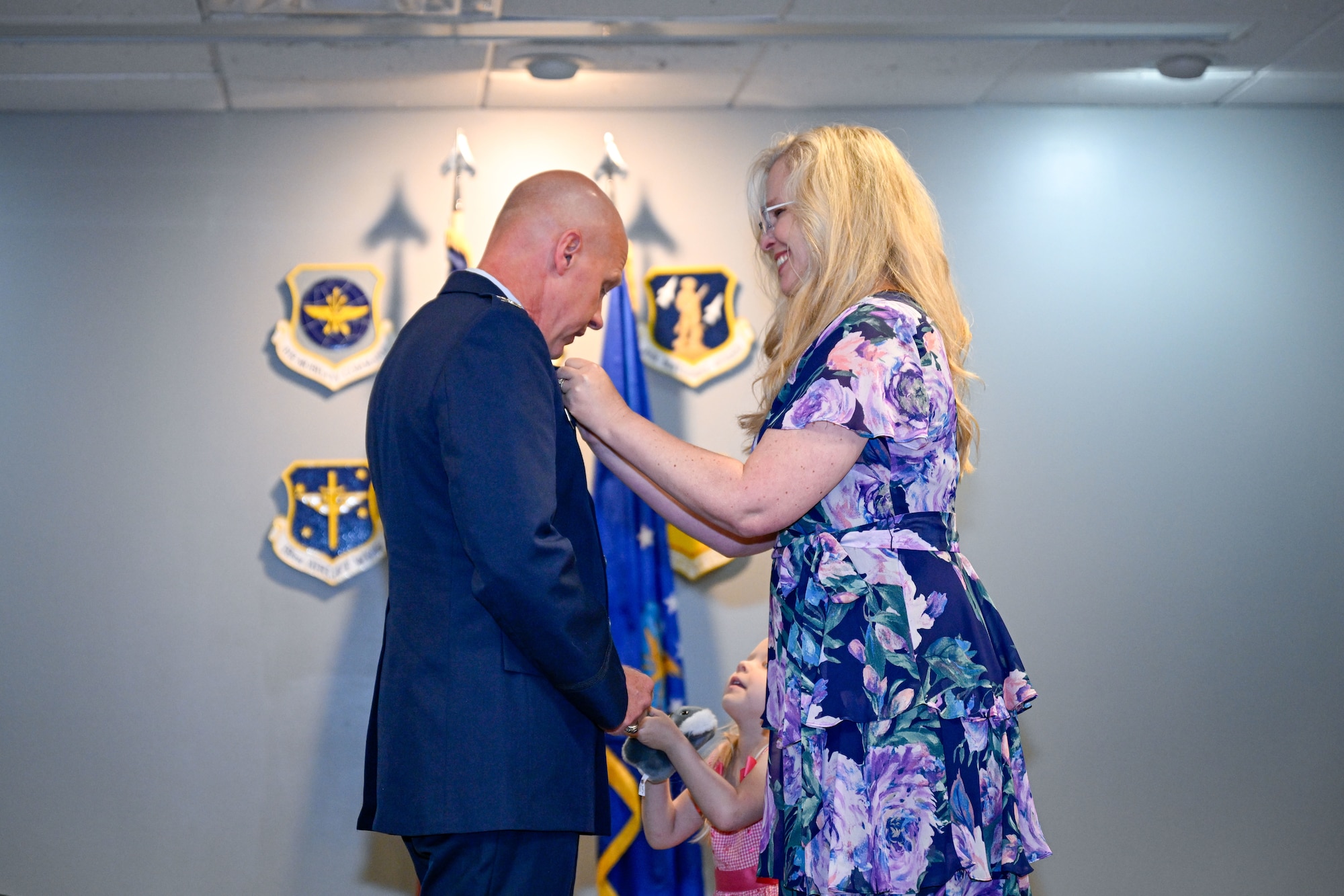A woman pins a man at a ceremony.