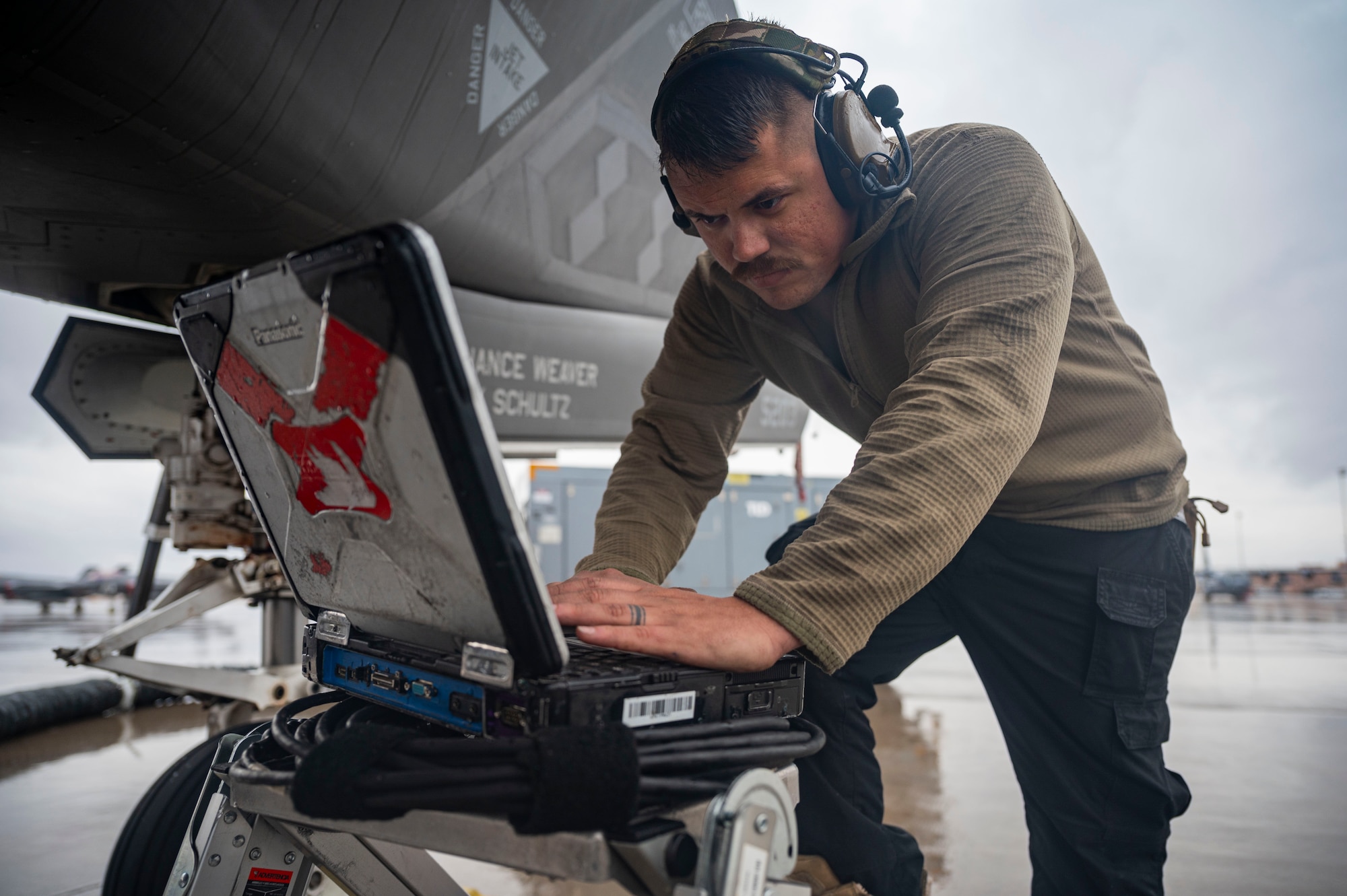 A photo of an F-35 maintainer working on his computer