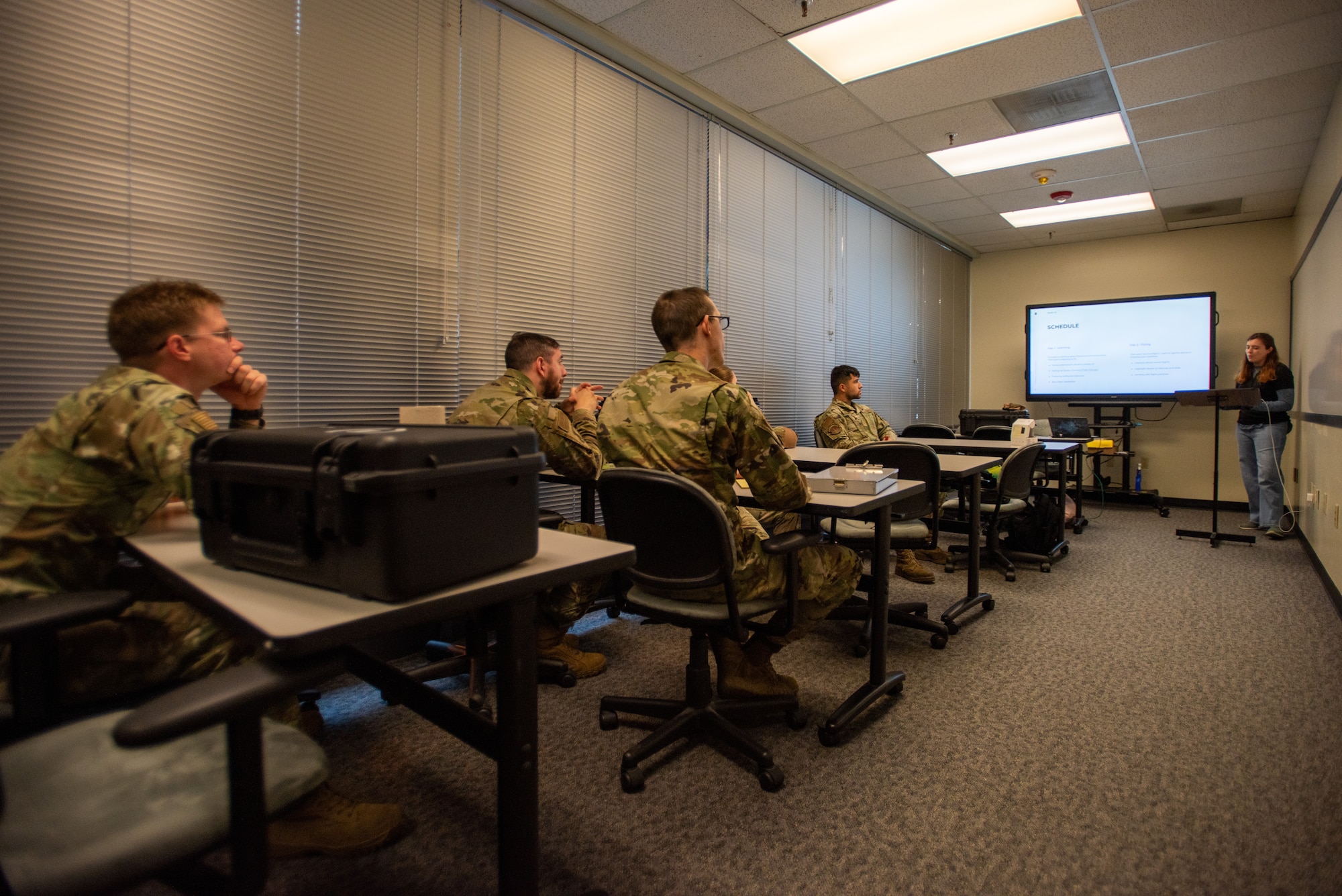 Airmen sit in class learning how to operate a drone