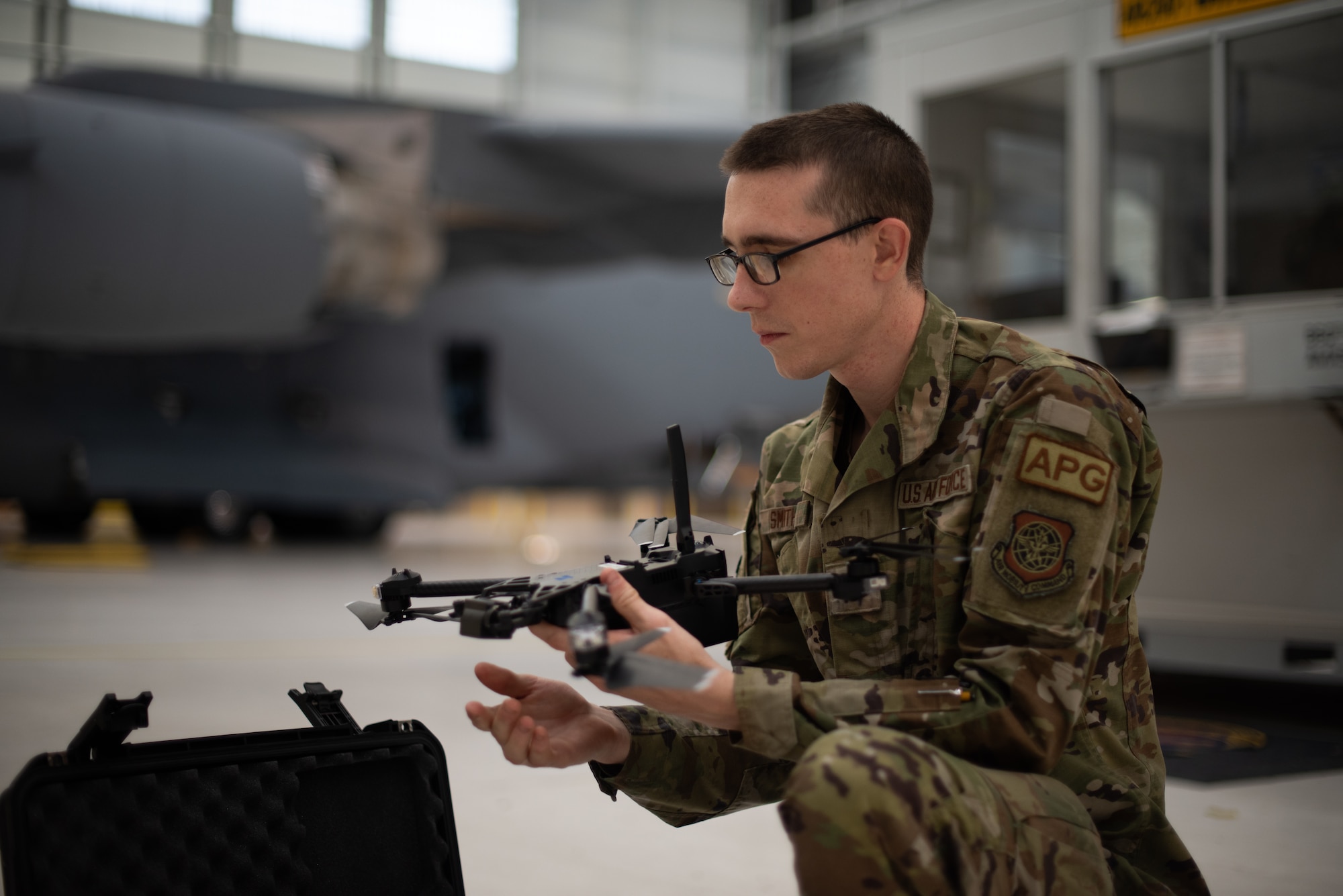 An airman holds a drone