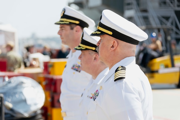 Rear Adm. Greg Newkirk, back, commander of Task Force 70 and Carrier Strike Group 5, Capt. Daryle Cardone, middle, commanding officer of Nimitz-class aircraft carrier USS Ronald Reagan (CVN 76), and Capt. Tim Waits, commanding officer of Nimitz-class aircraft carrier USS George Washington (CVN 73), stand on the pier during a press conference on Naval Air Station North Island, San Diego July 24, 2024.