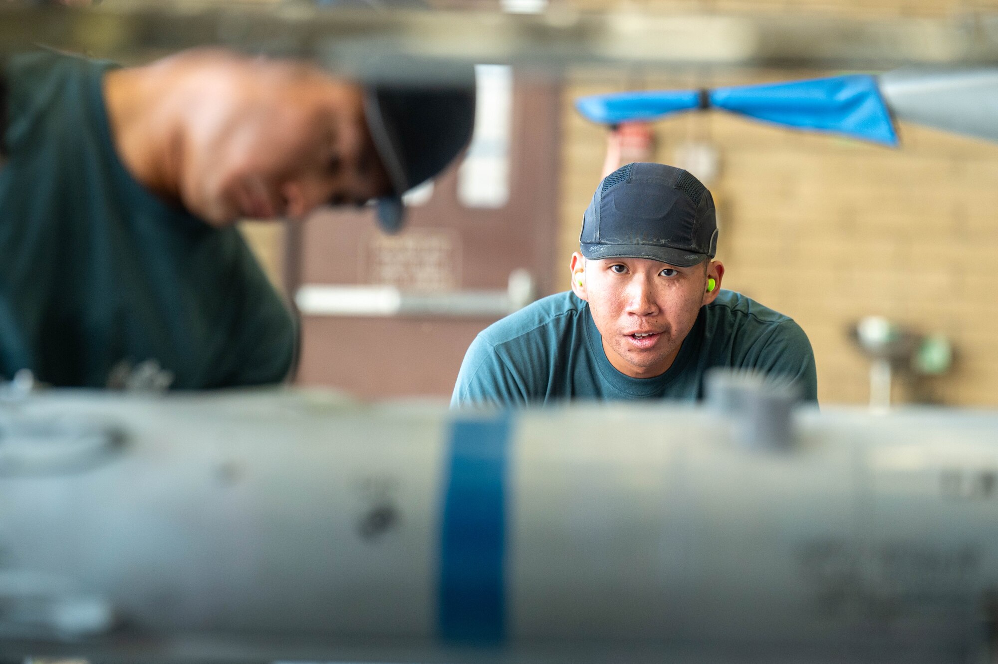 Republic of Singapore air force ME2 Jeff Hong (right), and ME2 Yong Hao Wong (left), load an AIM-120 AMRAAM missile during the 56th Maintenance Group 2nd quarter weapons load competition, July 12, 2024, at Luke Air Force Base, Arizona.