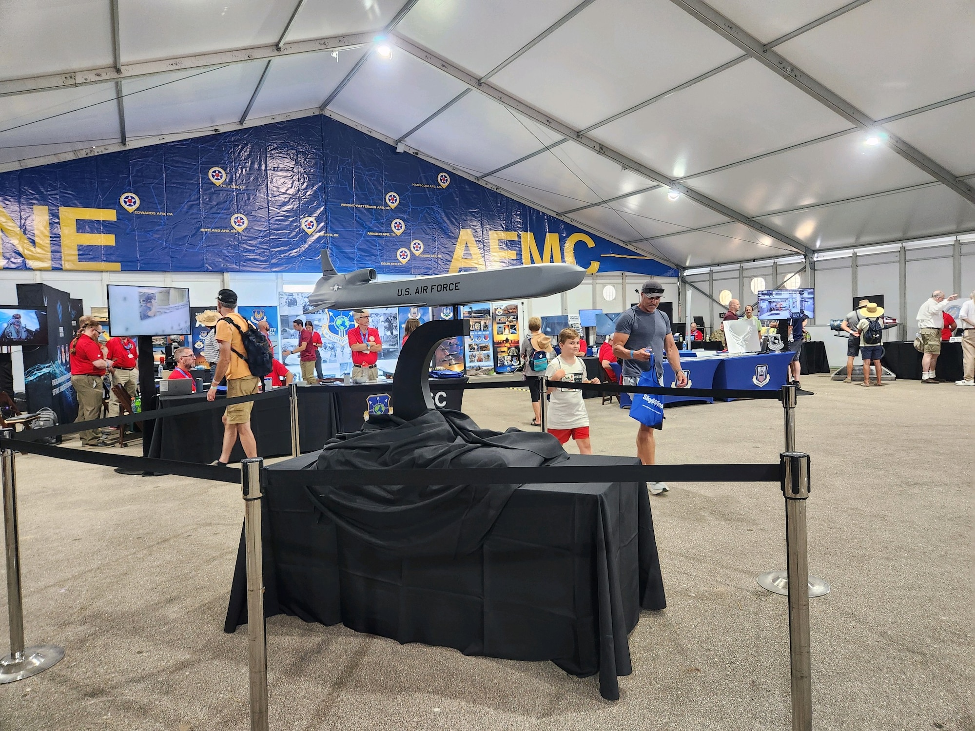 A model of a missile is set against the backdrop of a convention