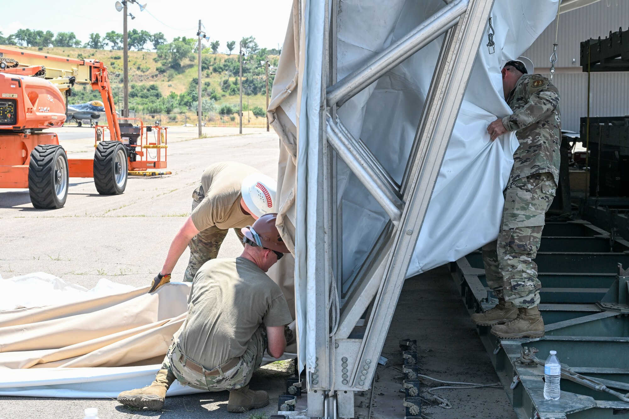 Airmen from the 635th Materiel Maintenance Squadron, based at Holloman Air Force Base, New Mexico, complete repairs on a clamshell tension fabric shelter system for 309th Aircraft Maintenance Group at Hill Air Force Base, Utah. The shelter stores critical aircraft parts and is used for “pack-and-crate” operations, where aircraft are prepared for ground or air transportation. (U.S. Air Force photo by Cynthia Griggs)