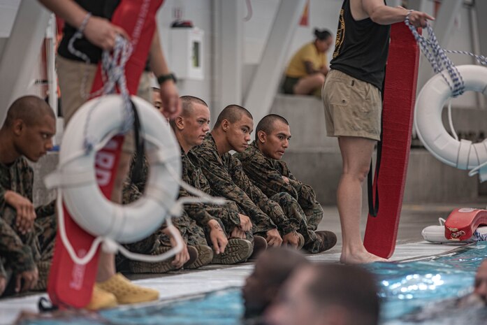 U.S. Marine Corps recruits with Fox Company, 2nd Recruit Training Battalion, wait to conduct the water survival training class at Marine Corps Recruit Depot San Diego, California, July 23, 2024. Recruits are taught basic water survival prior to conducting their basic swim qualification. Basic swim qualification consists of a 25-meter swim, a 10-foot tower jump into the water, four-minute tread, 25-meter pack swim and an underwater gear shed. (U.S. Marine Corps photo by Lance Cpl. Alexandra M. Earl)