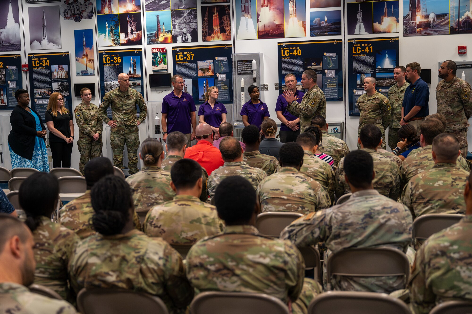 Service members address the Crew-9 crew members during an event.