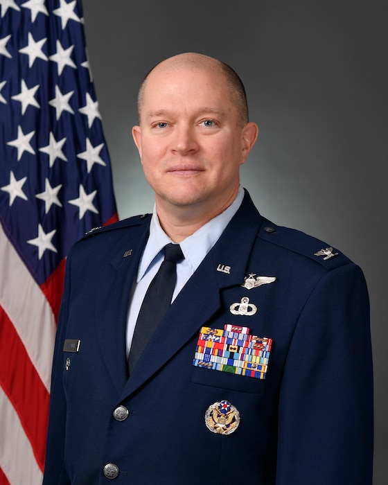 photo of U.S. Air Force Airman standing in front of U.S. flag